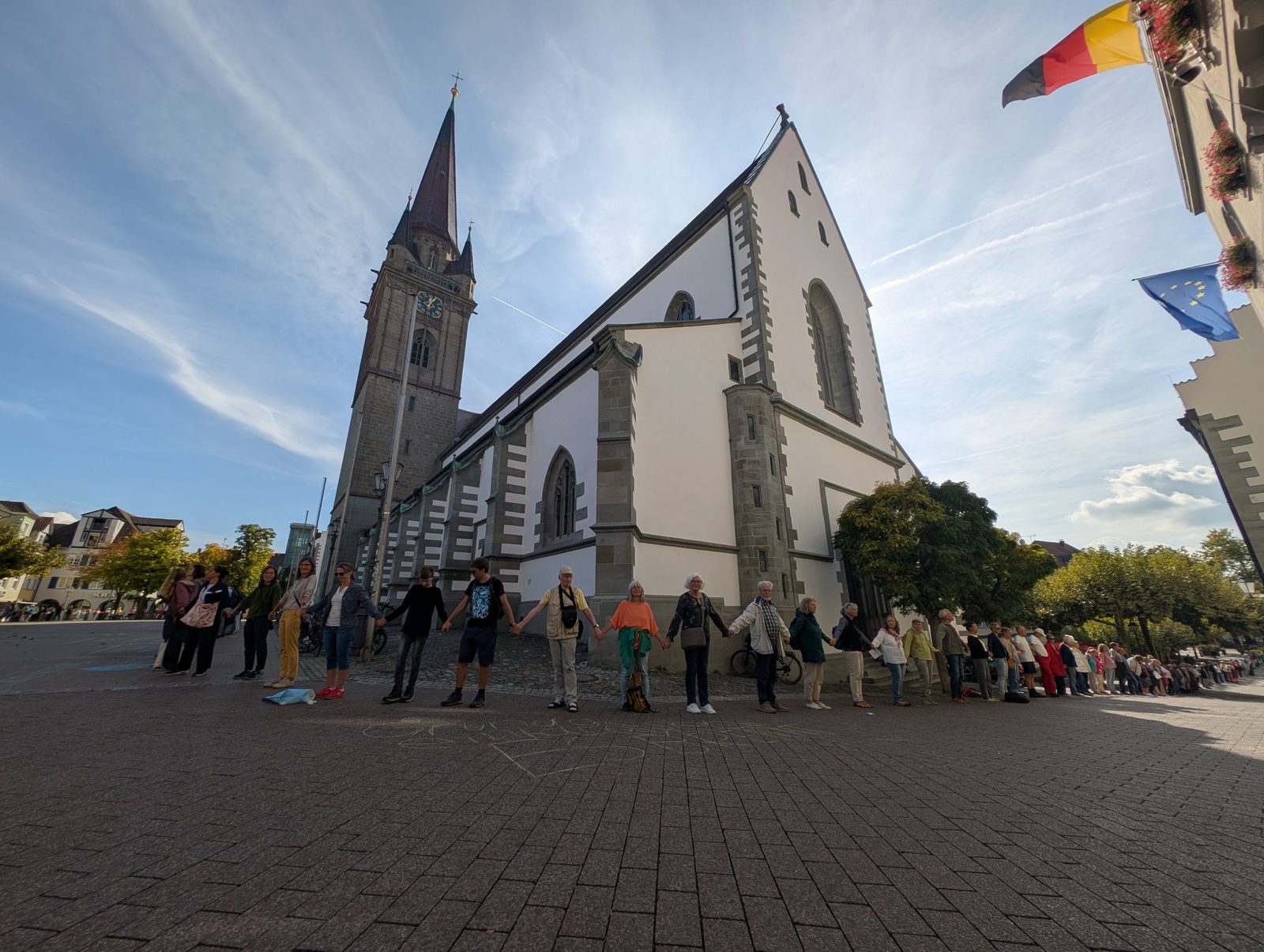 Menschenkette am Radolfzeller Münster, Teilnehmende halten sich an den Händen.