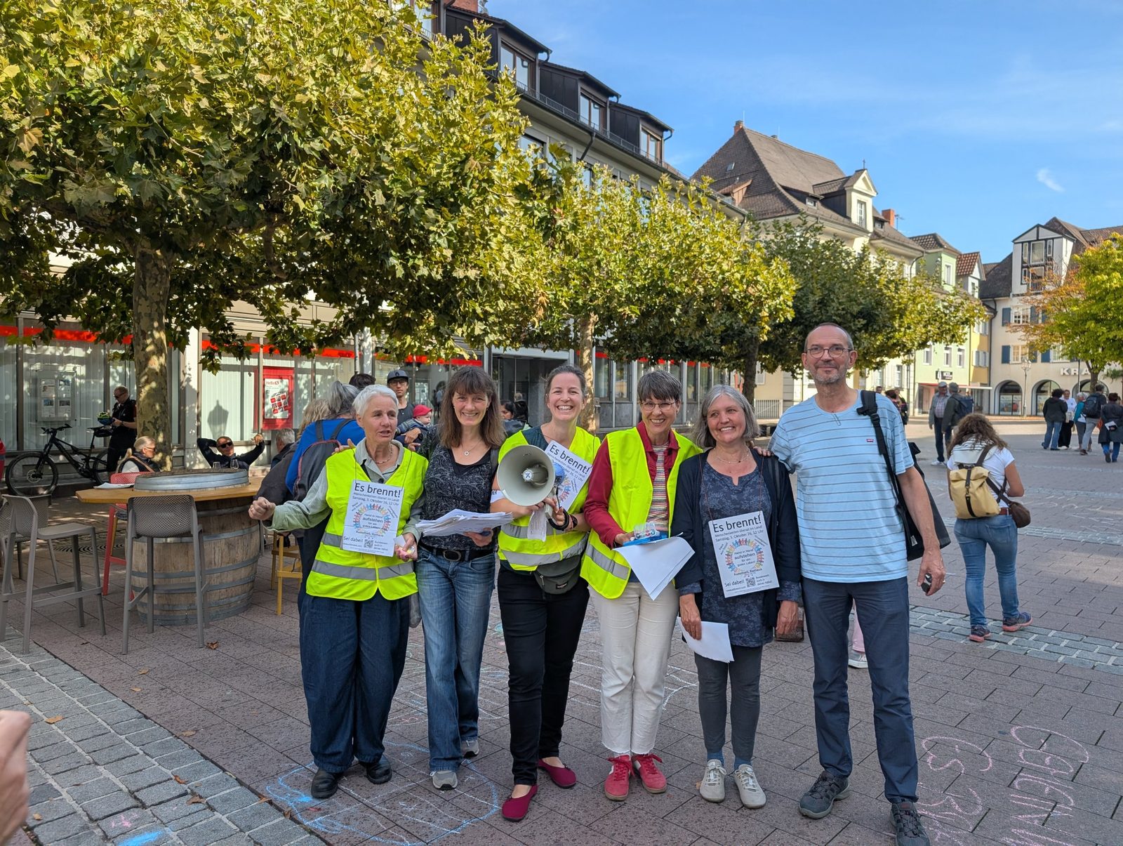 Das Orga-Team in Warnwesten mit Megafon auf dem Marktplatz.